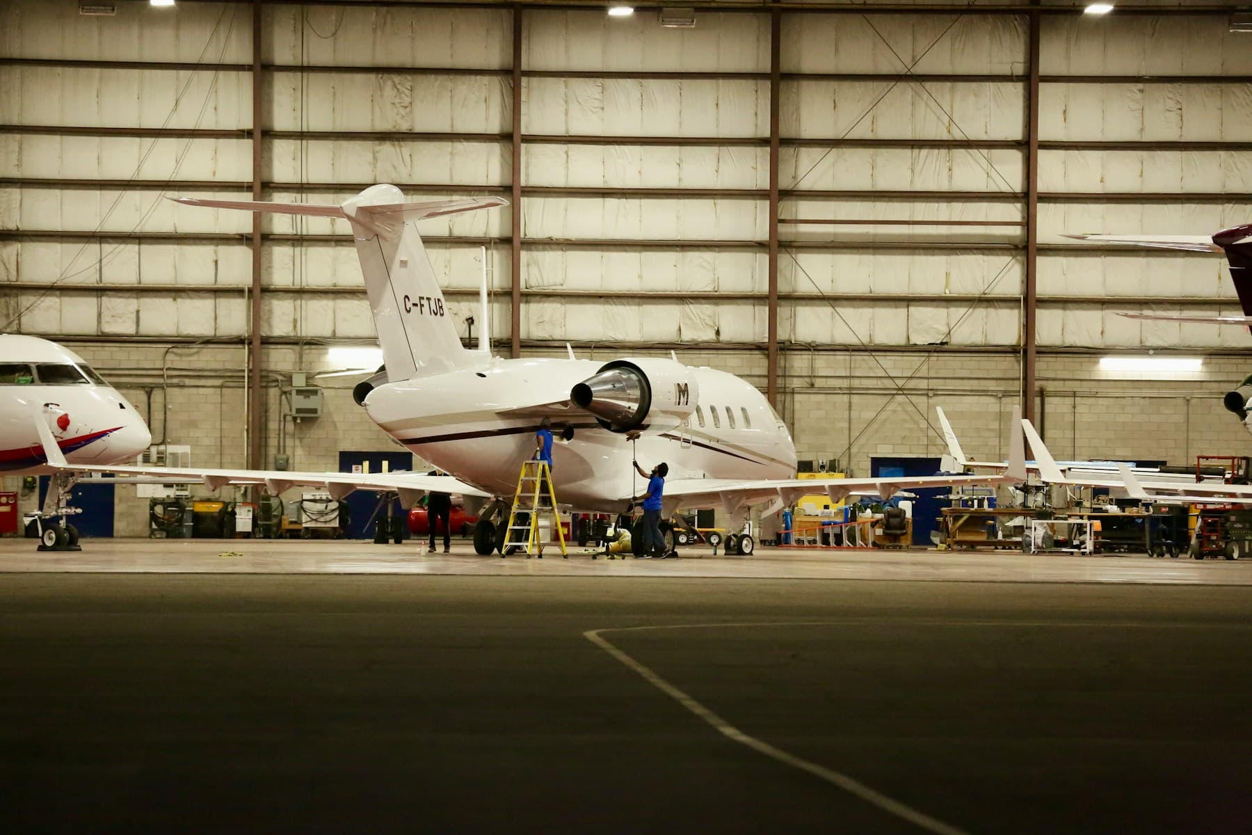 Aircraft undergoing readiness work inside a maintenance hangar